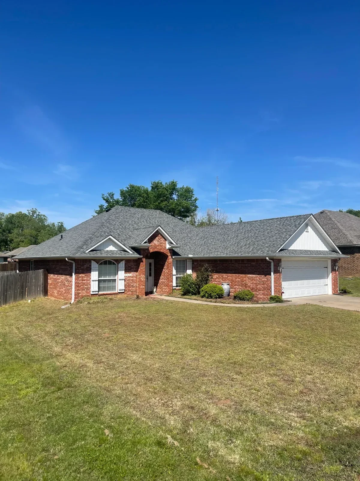 Gray architectural shingles installed on residential home roof with new gutters and flashing