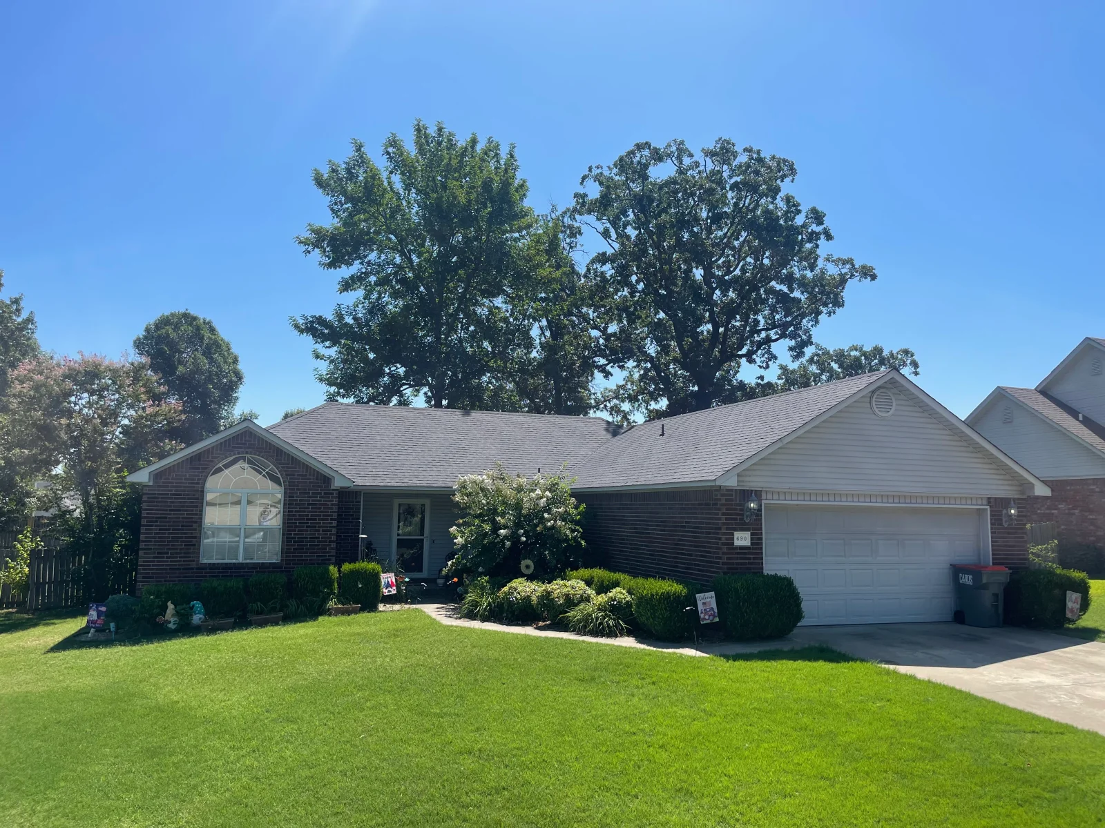 New gray architectural shingle roof on brick ranch home with garage